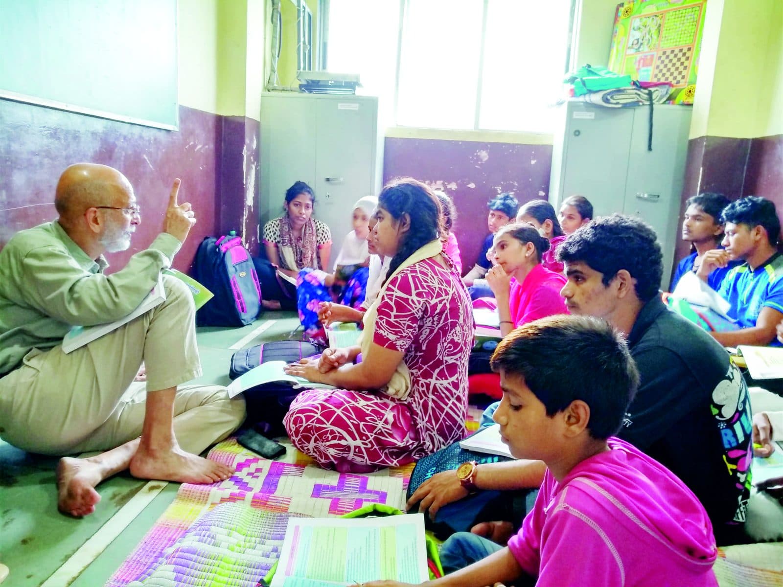 Volunteer mentoring a group of young students during a community learning session