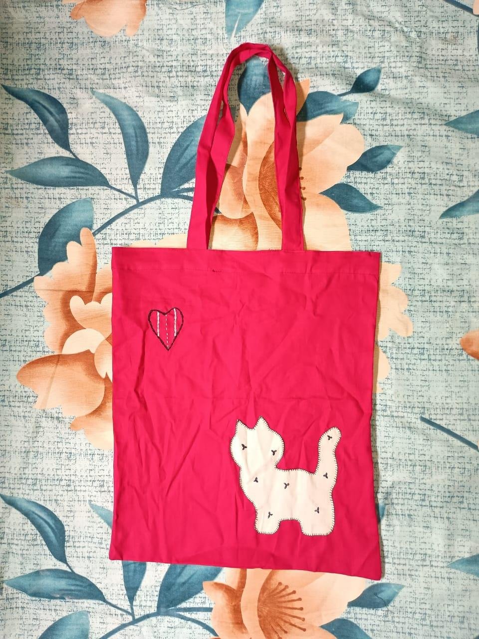 A fabric bag with an appliqué cat